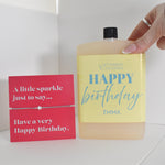 Bottle of letterbox cocktails with a happy birthday bracelet and personalised happy birthday cocktail on a white background