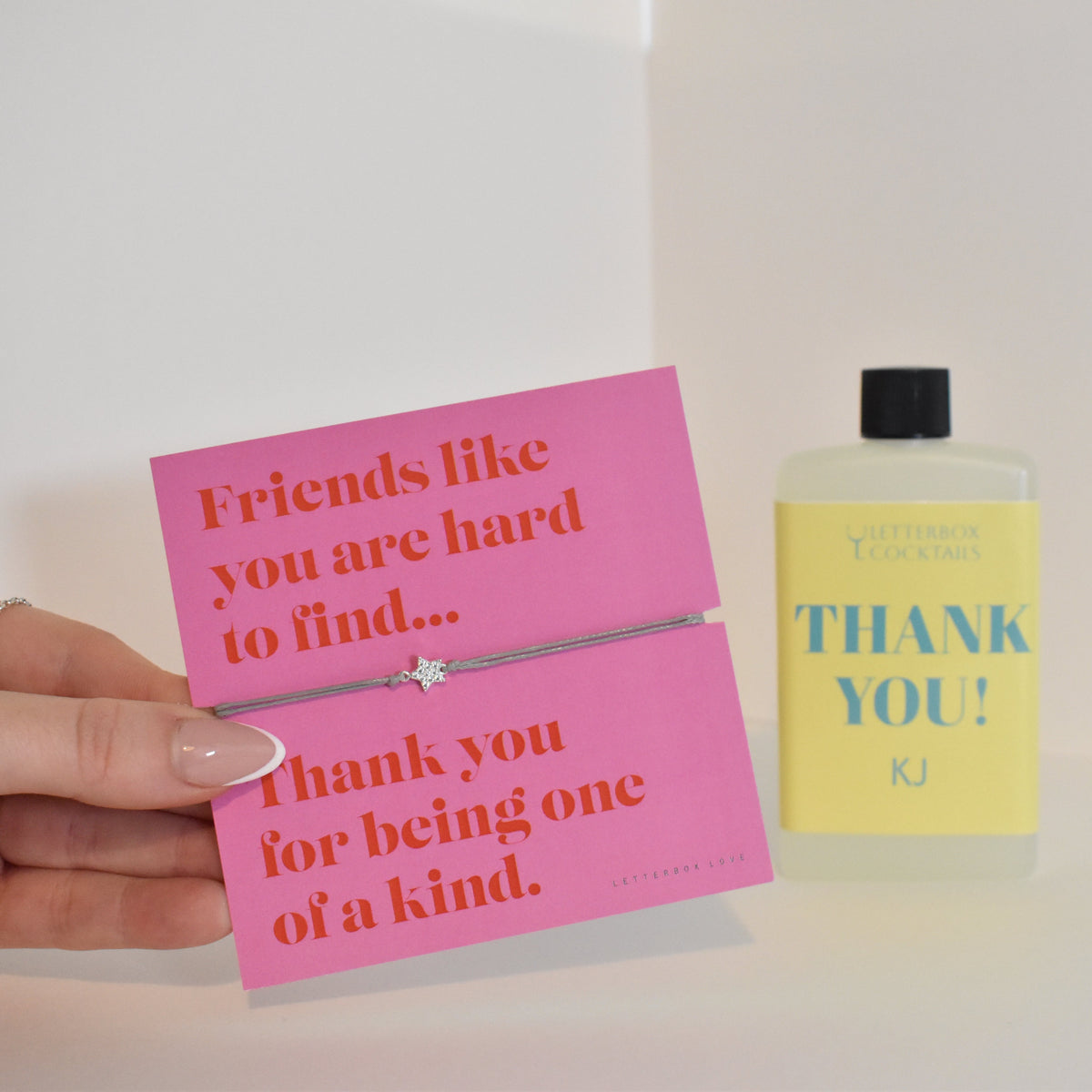 Bottle of letterbox cocktails with a pink thank you bracelet and personalised thank you cocktail on a white background